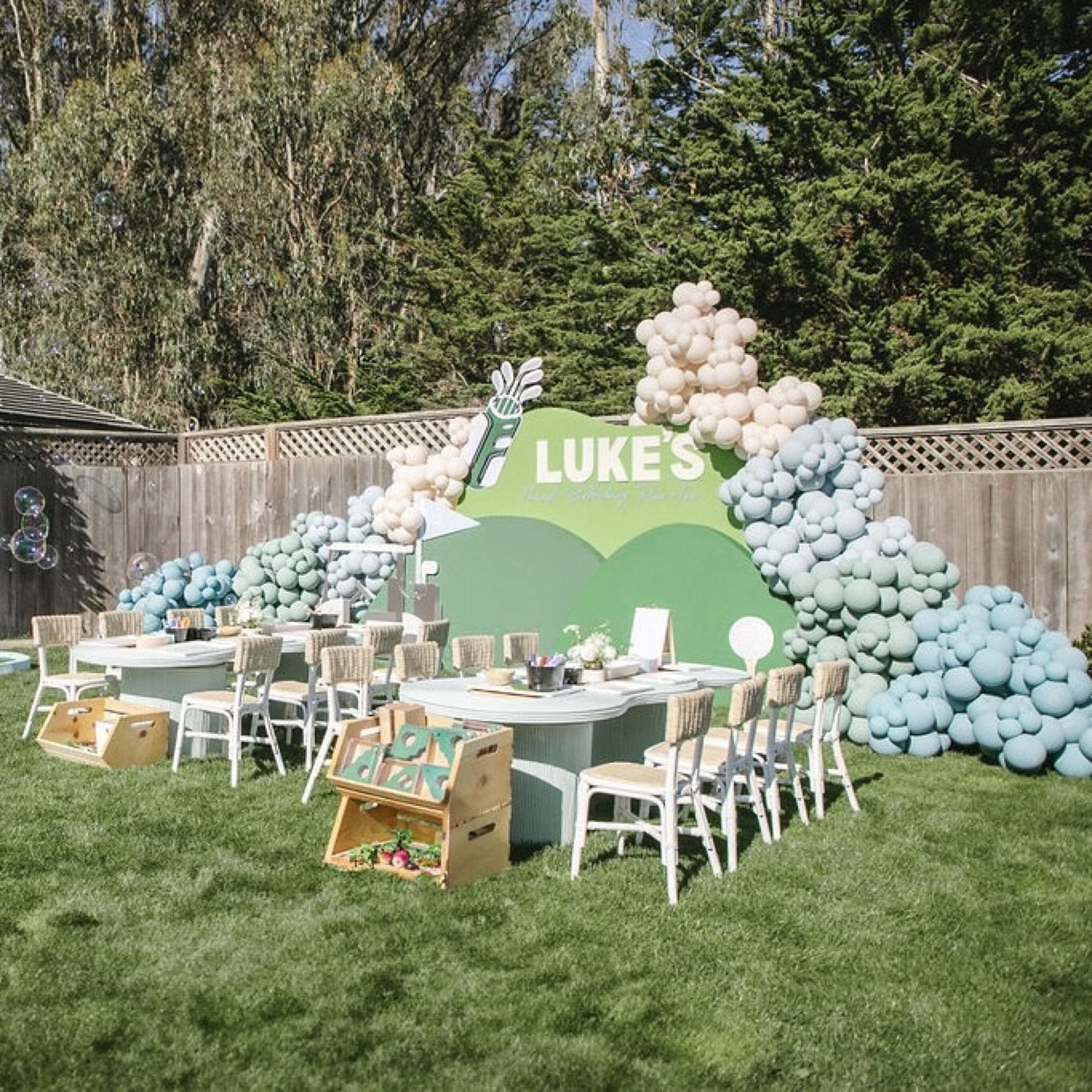 A styled kids party with tables, chairs and balloon garlands